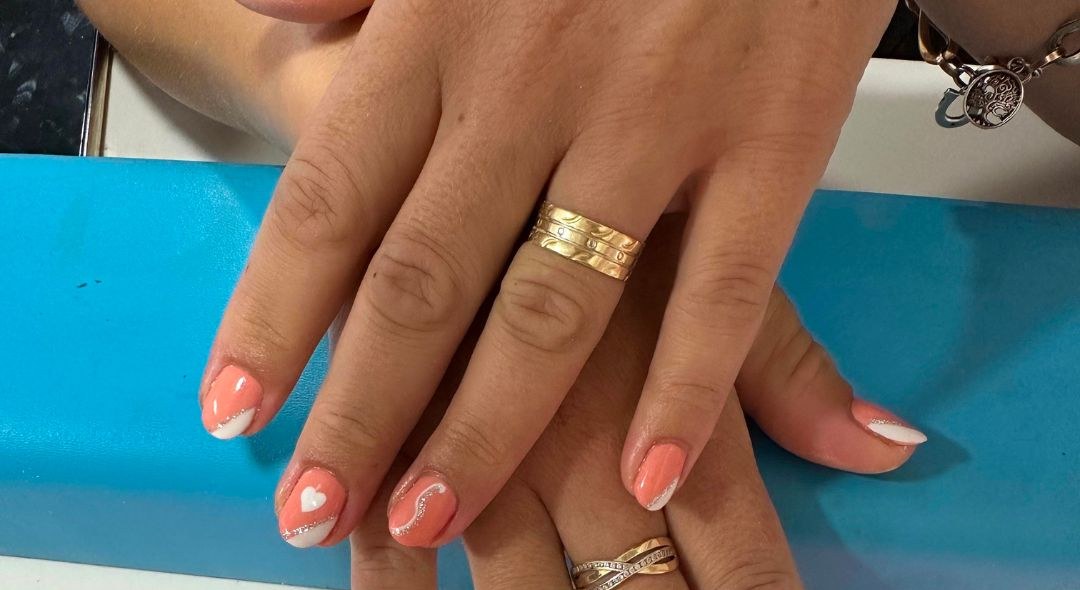 Perzikkleurige French tips met een klein hartje, gezet bij Melody Nails